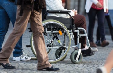 Pessoa em cadeira de rodas representando aposentadoria por invalidez cancelada pelo INSS.