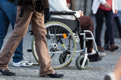 Pessoa em cadeira de rodas representando aposentadoria por invalidez cancelada pelo INSS.