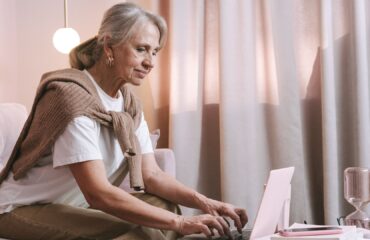 Mulher pesquisando informações sobre aposentadoria proporcional no computador
