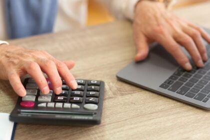Pessoa usando calculadora e computador para entender como calcular aposentadoria especial