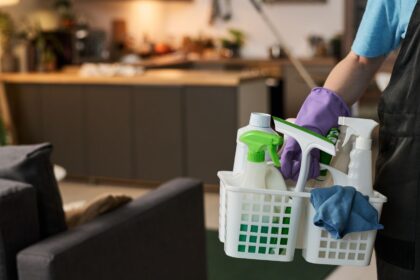 Profissional de trabalho doméstico com produtos de limpeza em uma residência