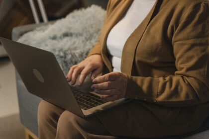 Mulher madura usando notebook em conteúdo sobre aposentadoria híbrida por idade