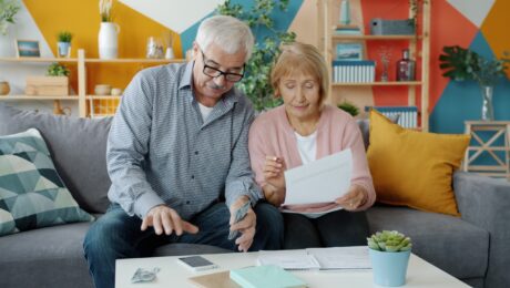 Casal de idosos analisando documentos em conteúdo sobre o que é pedágio na aposentadoria