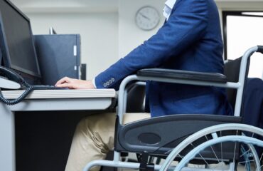 Profissional com deficiência utilizando cadeira de rodas no ambiente de trabalho