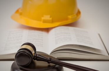 Capacete de segurança e martelo jurídico em conteúdo sobre supressão do adicional de insalubridade