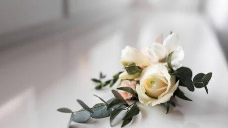 pensao-por-morte-direitos-inss Flor branca sobre superfície clara, simbolizando homenagem e amparo aos dependentes de segurados falecidos.