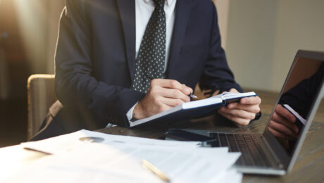 Advogado analisando documentos para recurso no INSS Advogado de terno analisando documentos e fazendo anotações em um escritório, representando a preparação de recurso no INSS.