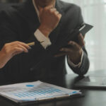 Gestores analisando gráficos financeiros e indicadores de inadimplência em um ambiente corporativo sob orientação jurídica.