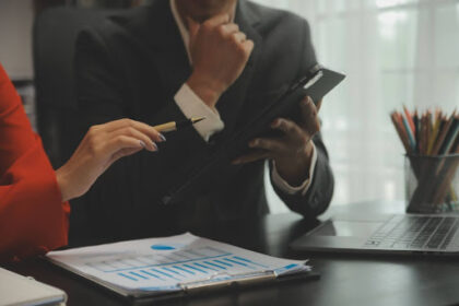 Gestores analisando gráficos financeiros e indicadores de inadimplência em um ambiente corporativo sob orientação jurídica.