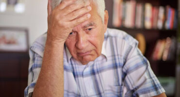 O que fazer após o indeferimento de aposentadoria em 2026 Senhor preocupado com a mão na testa após receber um indeferimento de aposentadoria do INSS.