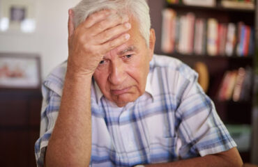 O que fazer após o indeferimento de aposentadoria em 2026 Senhor preocupado com a mão na testa após receber um indeferimento de aposentadoria do INSS.