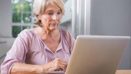 Consulta da tabela do INSS 2026 pela internet Idosa consultando informações da tabela do INSS 2026 no notebook em casa