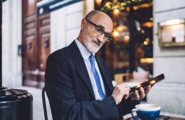 Bancário mais velho usando tablet, representando o tema aposentadoria para bancários