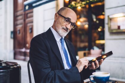 Bancário mais velho usando tablet, representando o tema aposentadoria para bancários
