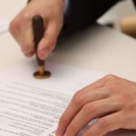 Profissional formalizando documento relacionado à diferença entre aval e fiança como garantias de uma obrigação