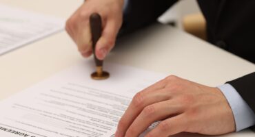 diferença entre aval e fiança Profissional formalizando documento relacionado à diferença entre aval e fiança como garantias de uma obrigação