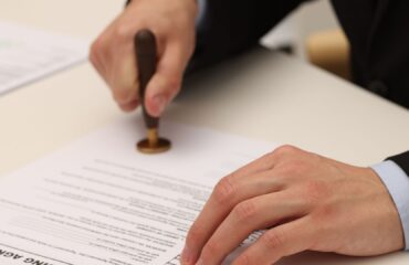 diferença entre aval e fiança Profissional formalizando documento relacionado à diferença entre aval e fiança como garantias de uma obrigação