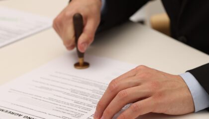 Profissional formalizando documento relacionado à diferença entre aval e fiança como garantias de uma obrigação
