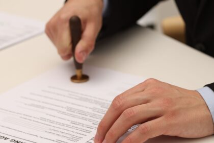 Profissional formalizando documento relacionado à diferença entre aval e fiança como garantias de uma obrigação