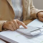 Profissional analisando documentos e valores relacionados ao prazo para cobrar dívida de clientes inadimplentes