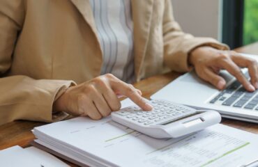 Profissional analisando documentos e valores relacionados ao prazo para cobrar dívida de clientes inadimplentes