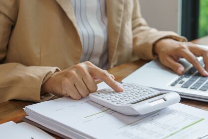 Profissional analisando documentos e valores relacionados ao prazo para cobrar dívida de clientes inadimplentes