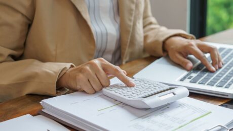 Profissional analisando documentos e valores relacionados ao prazo para cobrar dívida de clientes inadimplentes